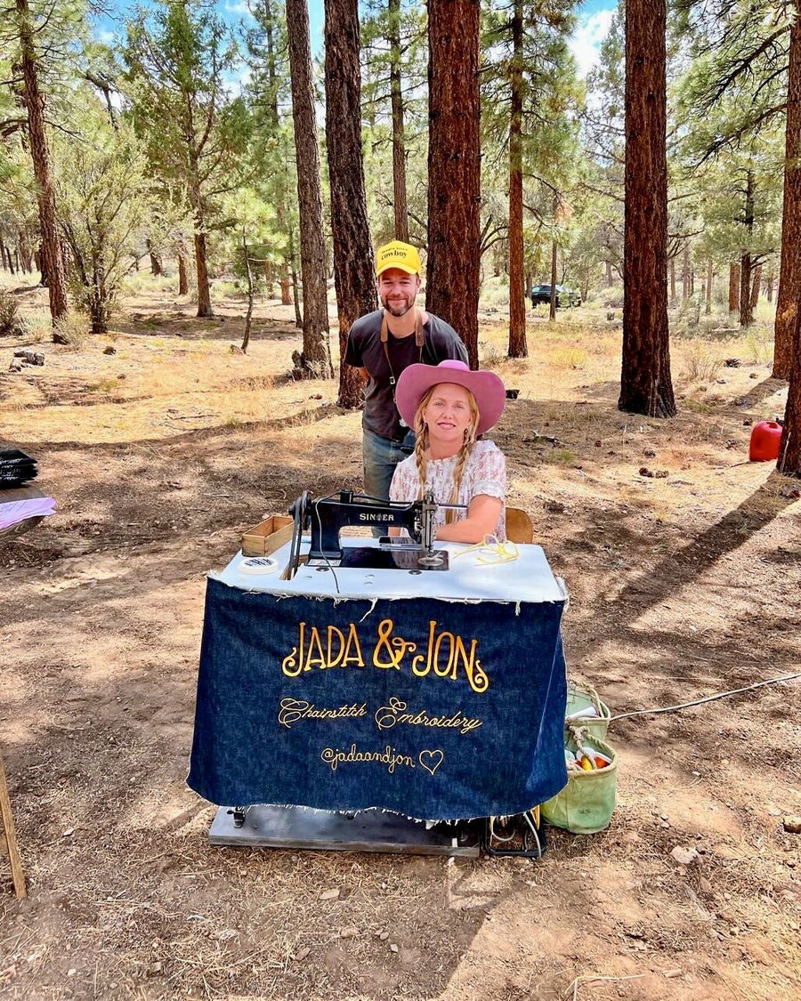 Jada in a pink hat at the Jada & Jon booth, Jon behind
