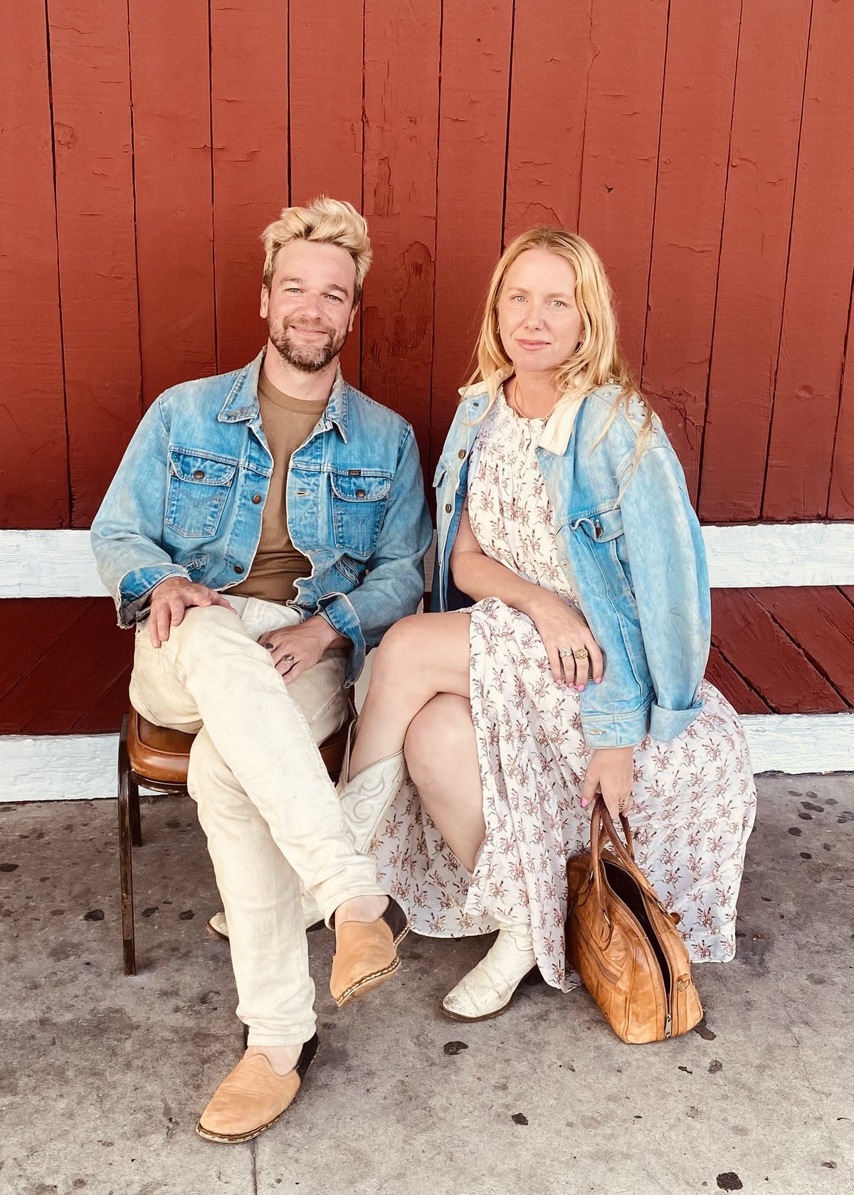 Jada and Jon in denim jackets against a red barn