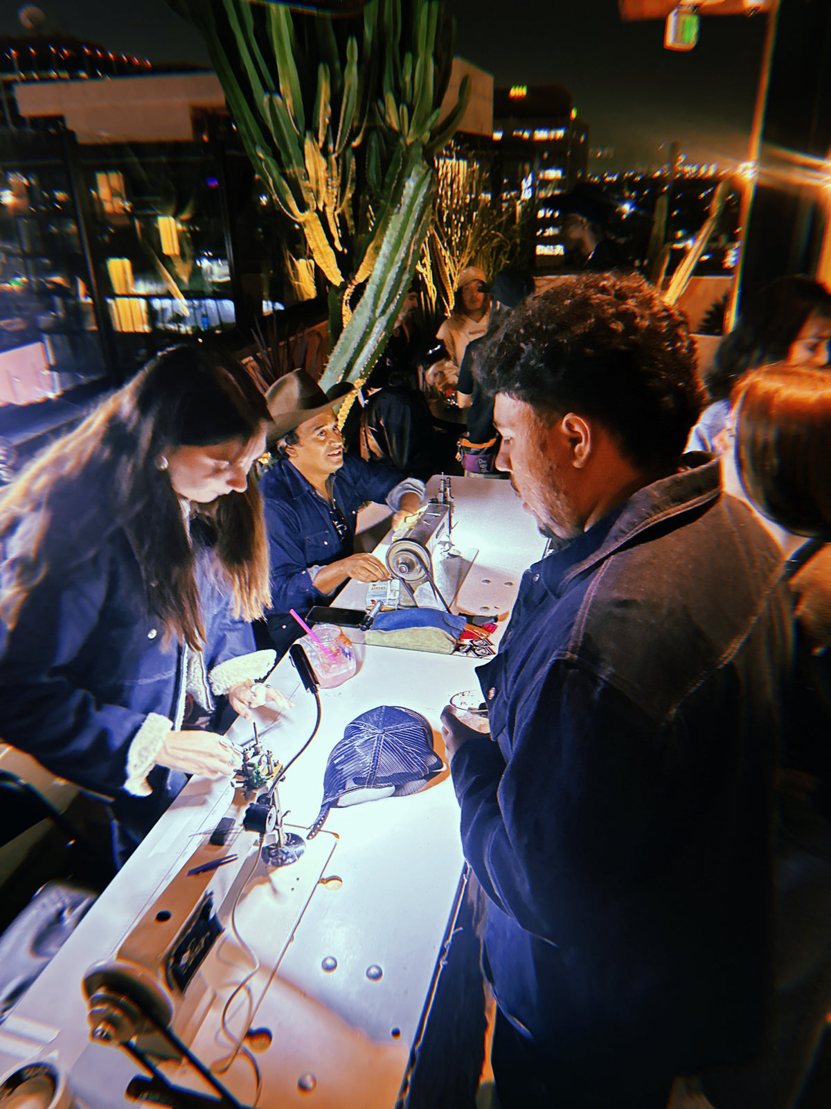 A crowd watching live chainstitch at night