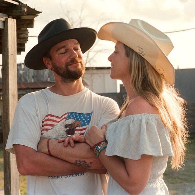 Jada and Jon in cowboy hats at golden hour